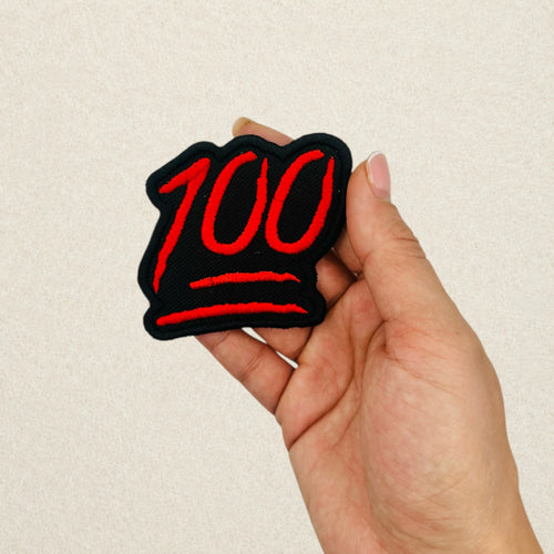100 Emoji embroidered patch shown in hand to demonstrate its actual size.