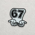 67 embroidered patch displayed on a light grey felt background.