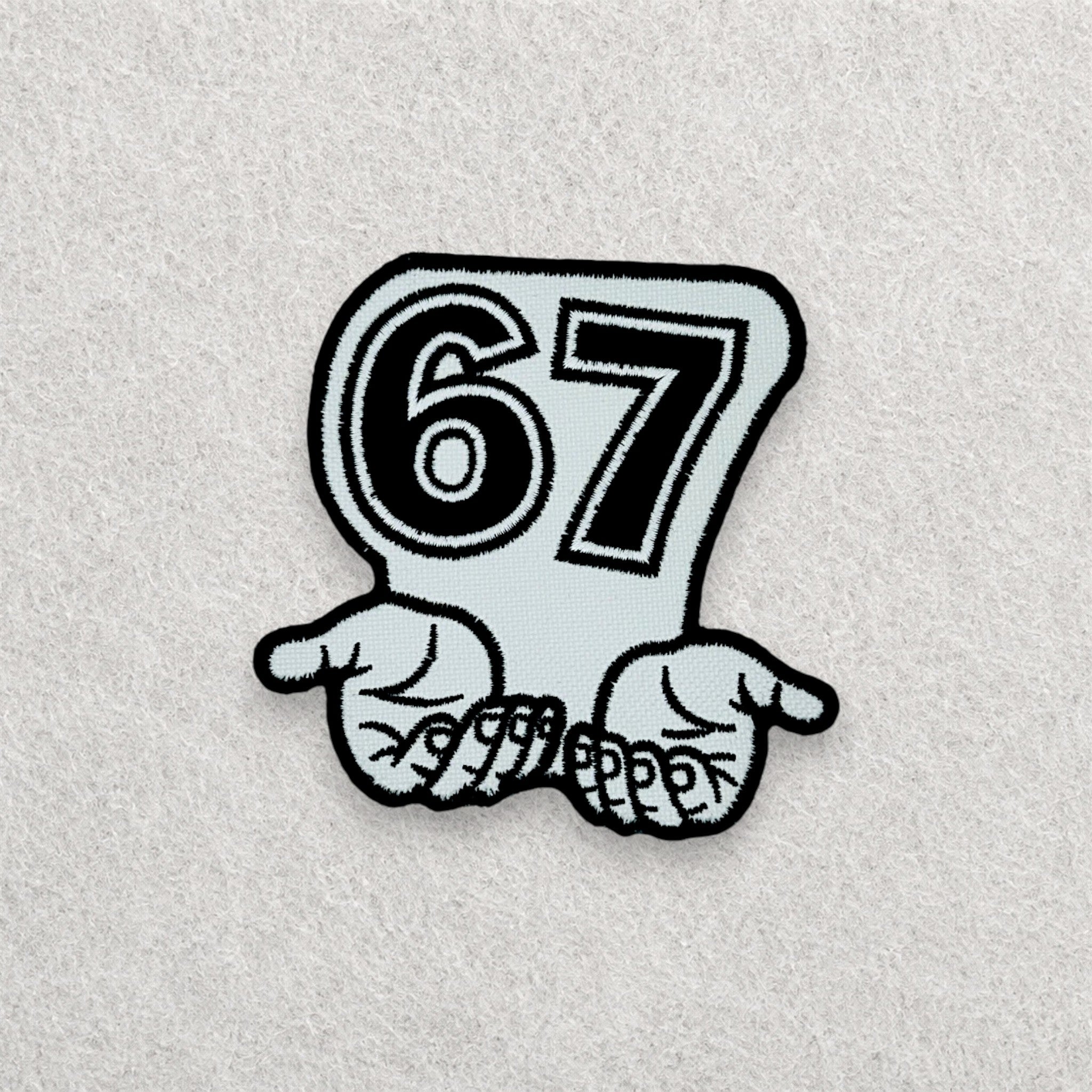 67 embroidered patch displayed on a light grey felt background.