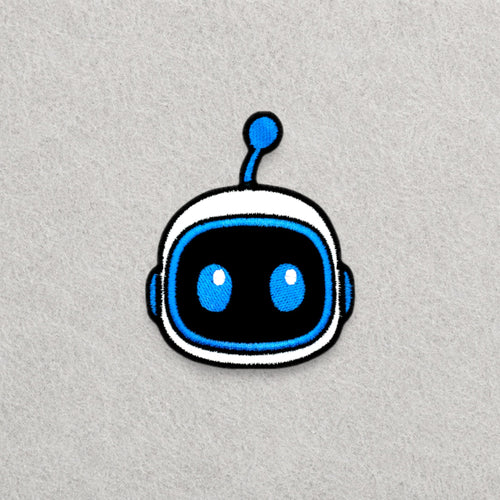 Astro Bot Head embroidered patch displayed on a light grey felt background.