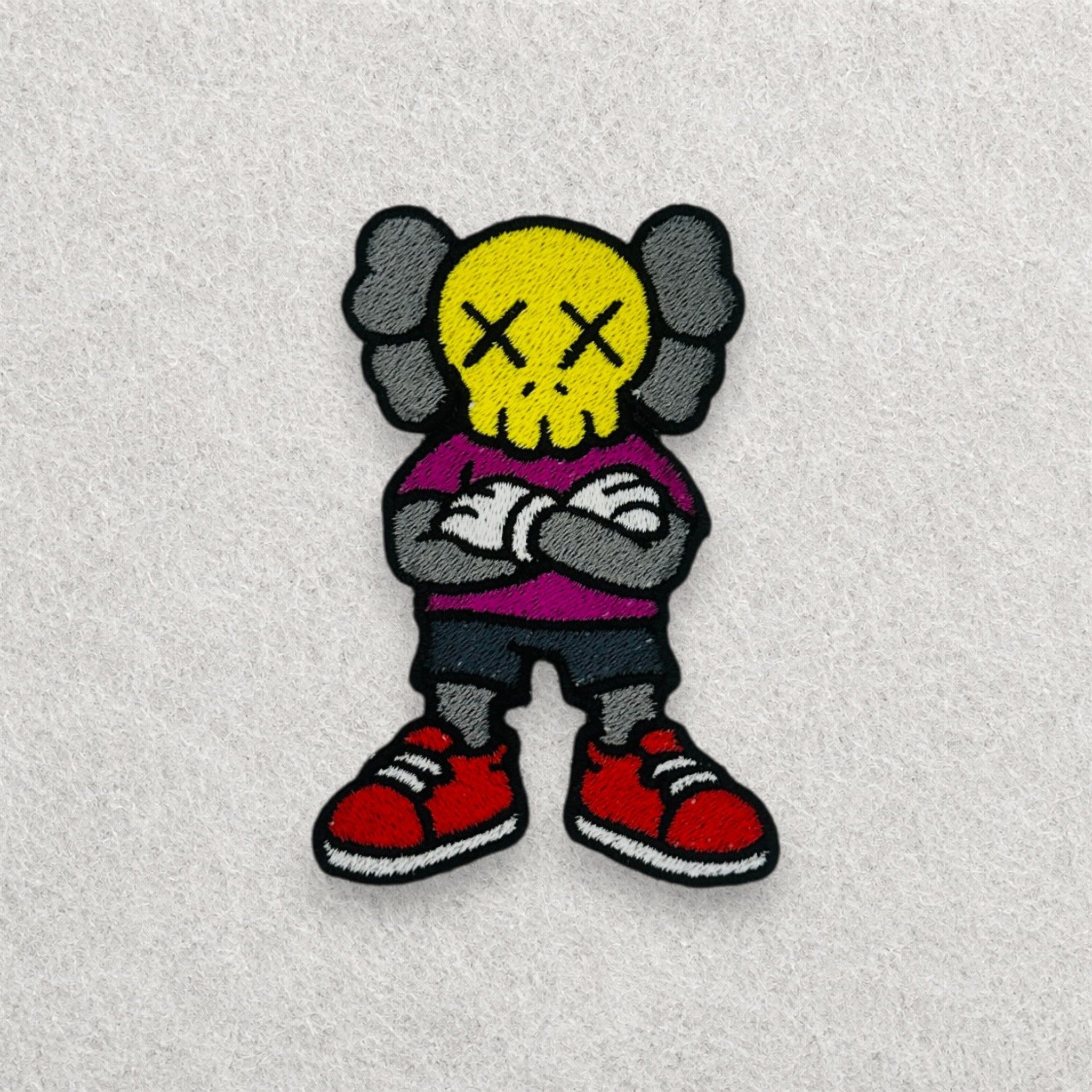 KAWS Companion embroidered patch displayed on a light grey felt background.