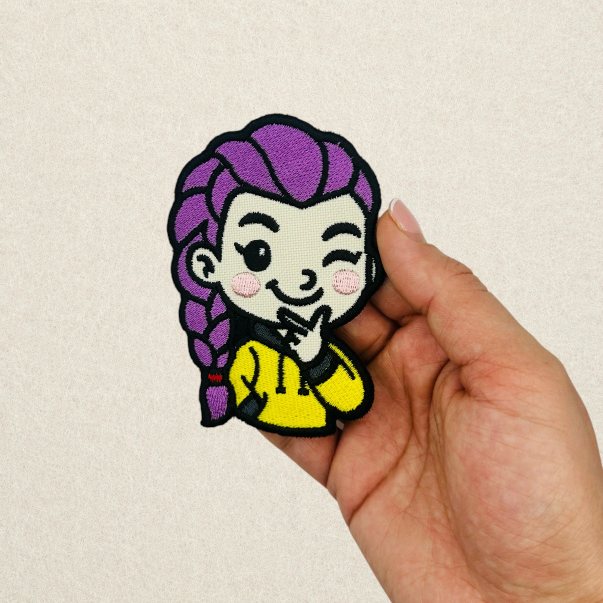 KPop Rumi inspired embroidered patch shown in hand to demonstrate its actual size.