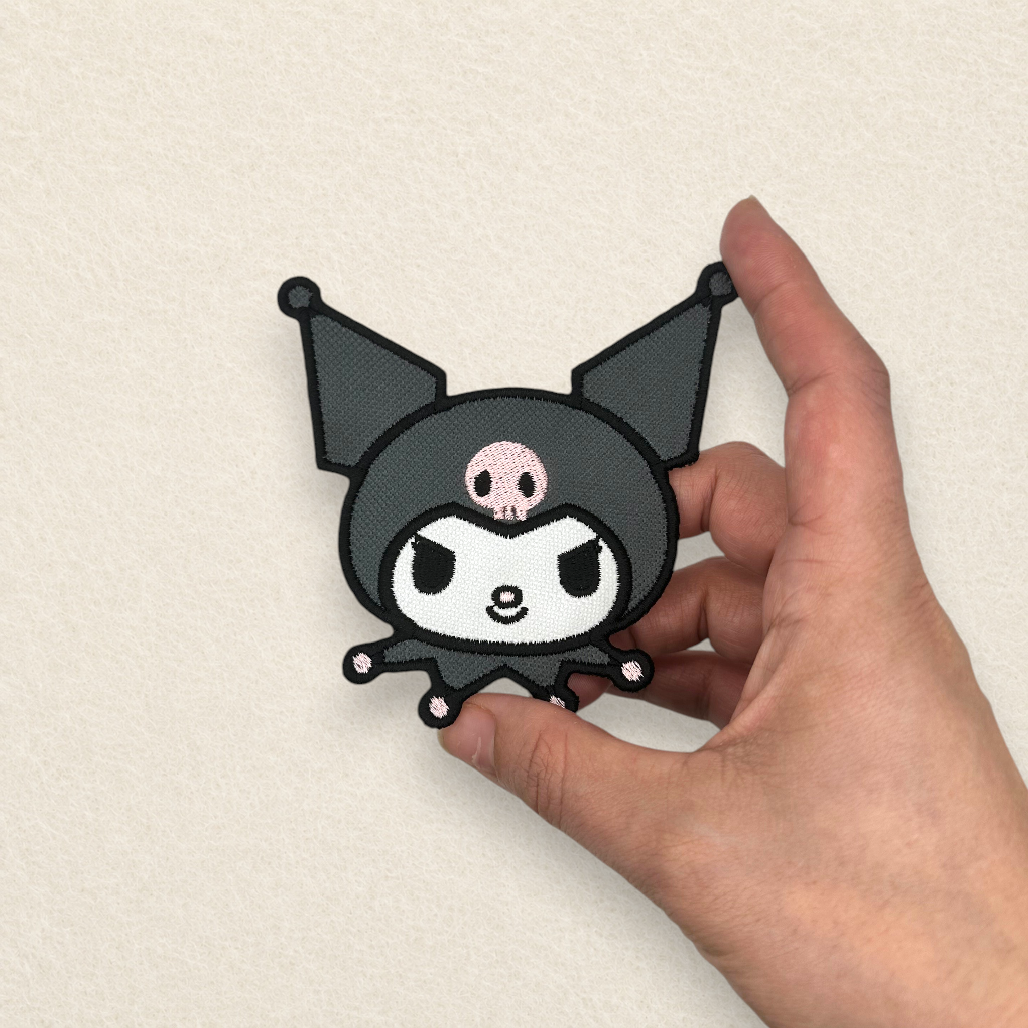 Close-up of a Kuromi inspired embroidered patch held in hand, showcasing the premium stitching, embroidered detail and finished size.