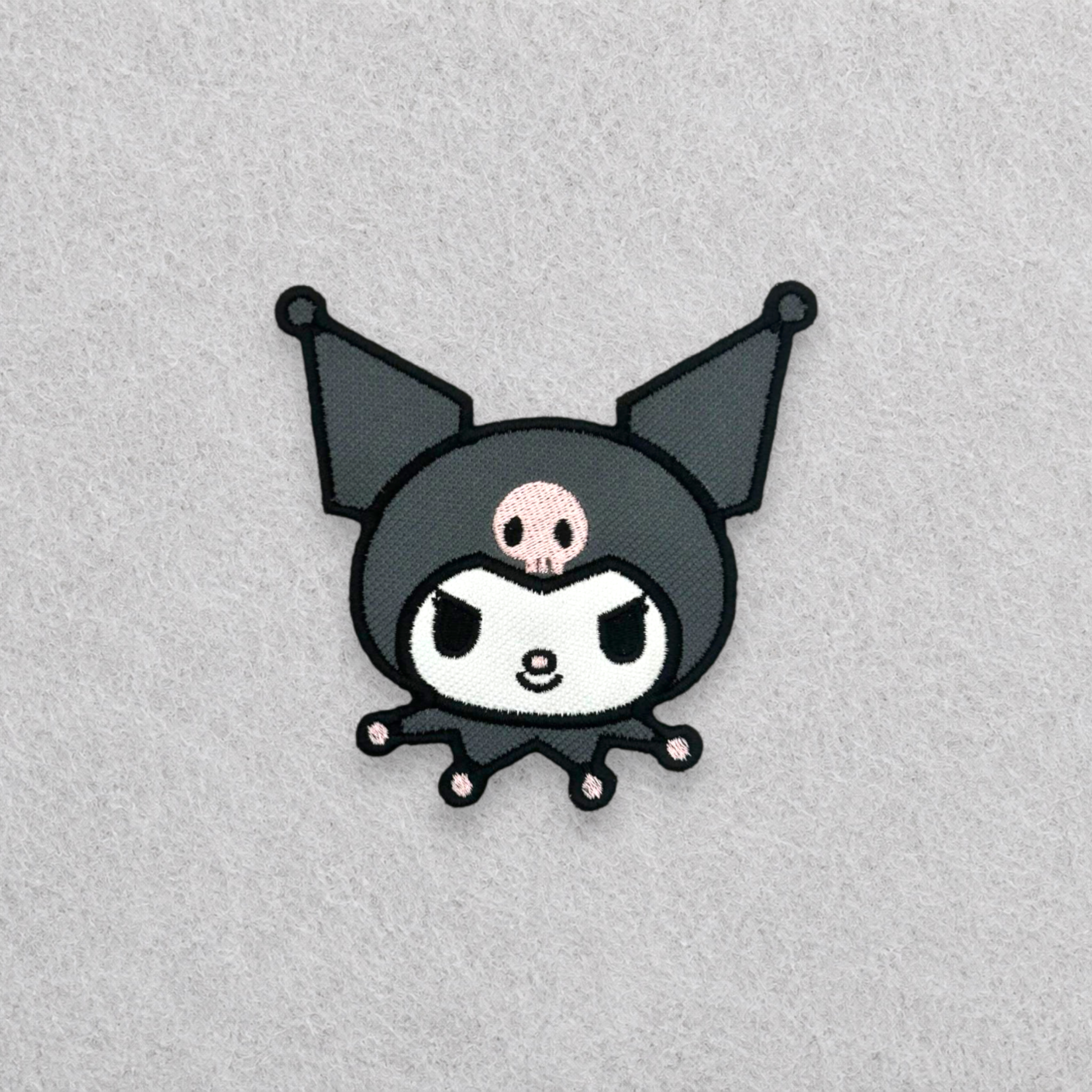 Kuromi inspired embroidered patch featuring the iconic black jester hood with pink skull and premium embroidered finish.