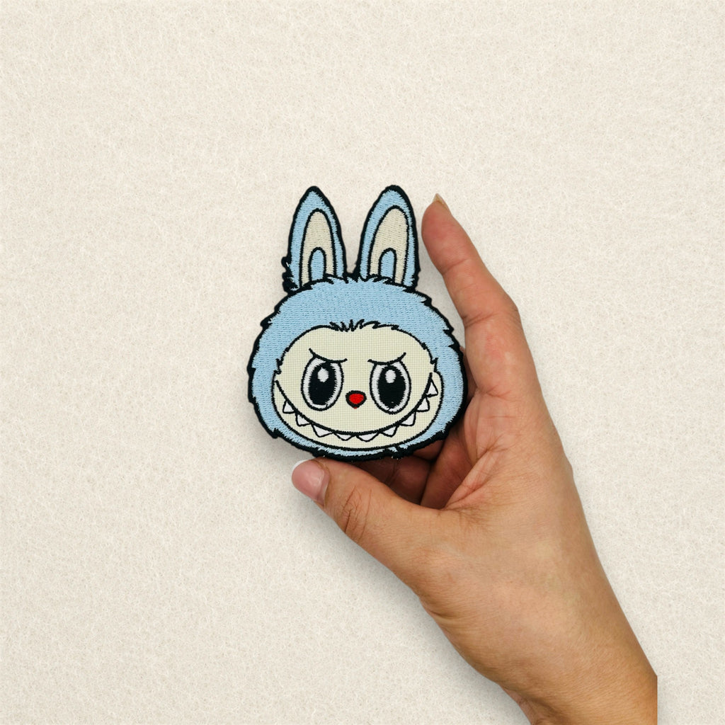 Labubu embroidered patch shown in hand to demonstrate its actual size.
