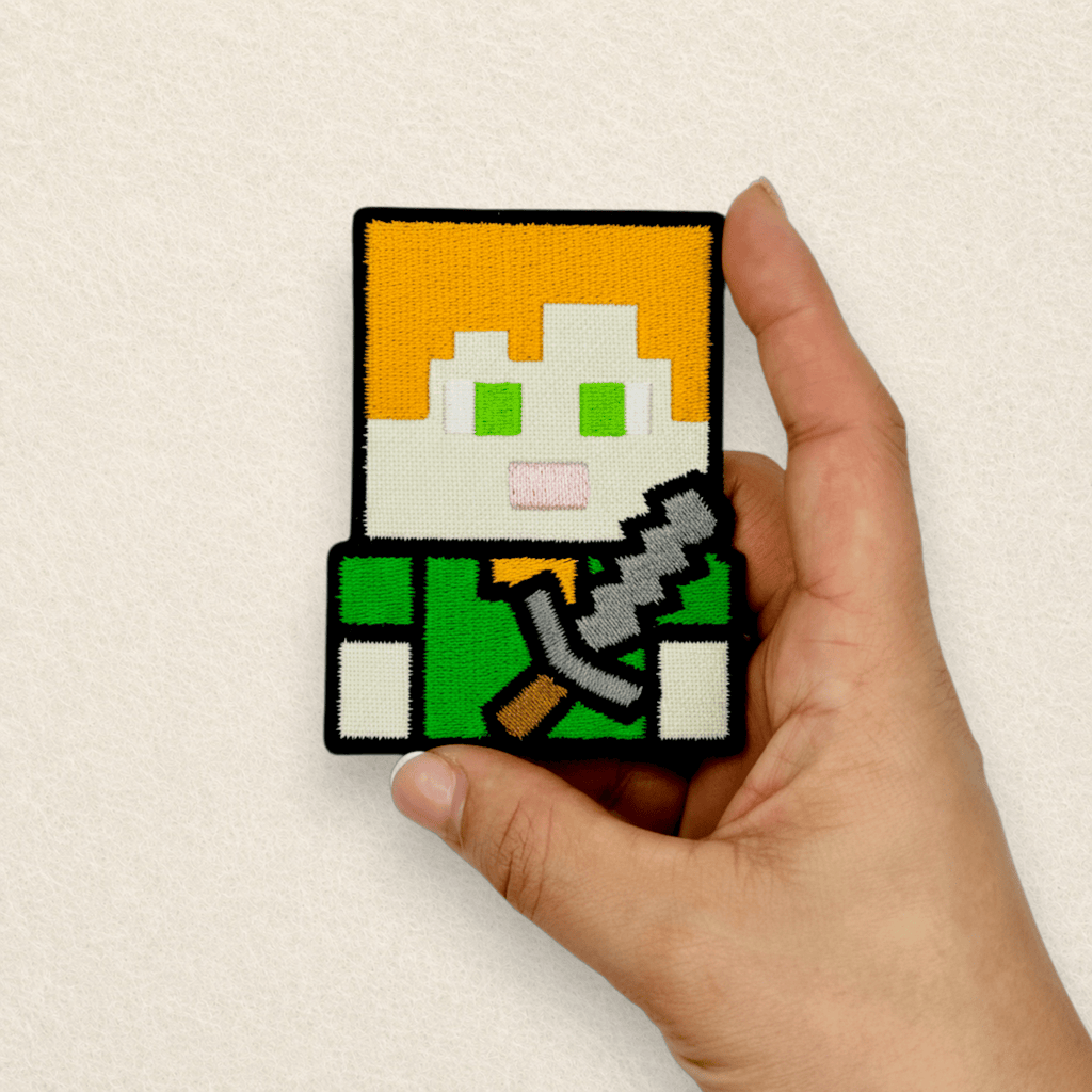 Close-up of a Minecraft Alex inspired embroidered patch showing detailed stitching and premium embroidered finish held in hand.