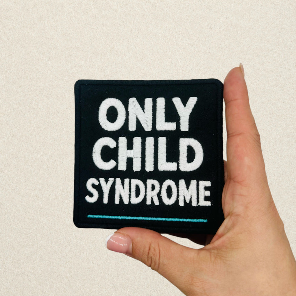 Only Child Syndrome embroidered morale patch shown in hand to demonstrate its actual size.
