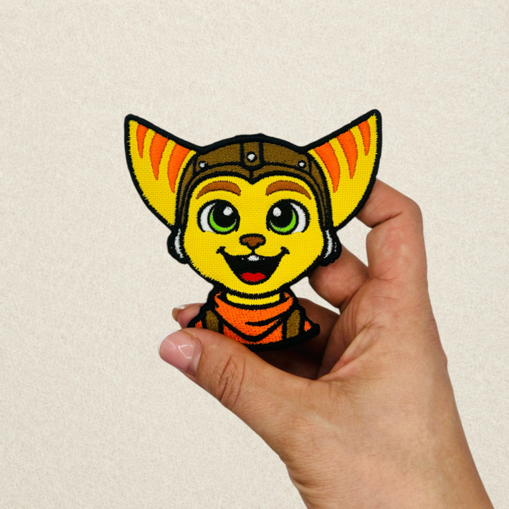 Ratchet inspired embroidered patch shown in hand to demonstrate its actual size.