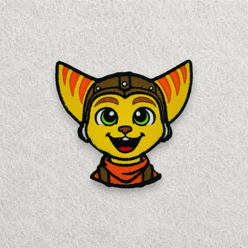 Ratchet inspired embroidered patch displayed on a light grey felt background.