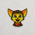 Ratchet inspired embroidered patch displayed on a light grey felt background.