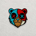 Split Face Bear embroidered patch displayed on a light grey felt background.
